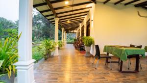 a porch with a table and chairs and plants at Tranquil Guest in Sigiriya