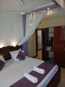 a bedroom with a bed with two towels on it at Kariba 8 in Mombasa