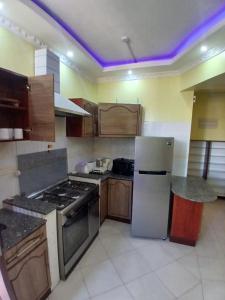 a kitchen with a stove and a white refrigerator at Kariba 8 in Mombasa