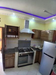 a kitchen with a stove and a refrigerator at Kariba 8 in Mombasa