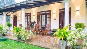 a house with a porch with a table and chairs at Tranquil Guest in Sigiriya