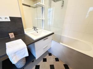 a bathroom with a sink and a tub and a mirror at Studio au cœur du château in Monchy-Humières
