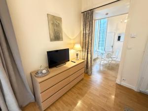 a living room with a flat screen tv on a dresser at Studio au cœur du château in Monchy-Humières