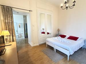 a white bedroom with a bed and a mirror at Studio au cœur du château in Monchy-Humières