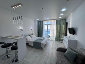 a bedroom with a bed and a desk and a couch at Batumi in the waves in Batumi