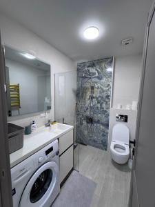 a bathroom with a washing machine and a toilet at Batumi in the waves in Batumi +9 photos