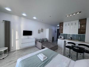 a living room with a bed and a kitchen at Batumi in the waves in Batumi