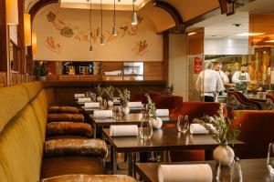 a restaurant with tables and chairs and people in the background at South Lodge in Horsham