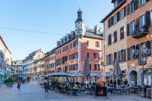 a group of people sitting at tables on a city street at Glamour & jacuzzi privé Chambéry in Chambéry