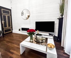 a living room with a tv and a white coffee table at Glamour & jacuzzi privé Chambéry in Chambéry