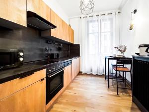 a kitchen with wooden cabinets and a table in it at Glamour & jacuzzi privé Chambéry in Chambéry