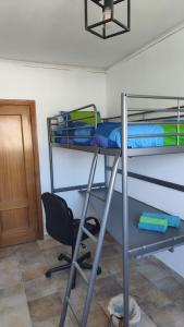 a room with two bunk beds and a chair at Casa Flamenca en El Ventorrillo - Piscina, Tumbonas, Terraza y Aparcamiento in Cúllar-Vega