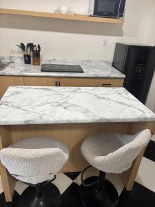 a kitchen with a counter with two chairs and a counter top at Bello Departamento Completo con 2 recámaras! in San Baltasar +16 photos