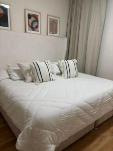 a white bed with pillows on it in a room at Bello Departamento Completo con 2 recámaras! in San Baltasar