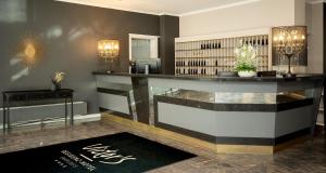 a lobby with a counter and a book shelf at Victor's Residenz-Hotel Saarlouis in Saarlouis