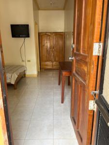 a room with a room with a table and a television at Hollywood Beachfront Bed & Breakfast in Mamburao