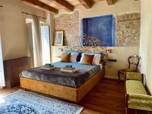 a bedroom with a large bed and a chair at La Blu di Via Silvano 8 in Monforte dʼAlba