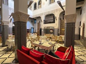 a restaurant with red chairs and tables in a room at Riad Fes Bab Rcif Suite &Spa in Fez
