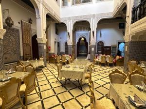 a restaurant with tables and chairs in a room at Riad Fes Bab Rcif Suite &Spa in Fez