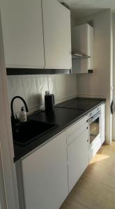 a kitchen with white cabinets and a black counter top at Casa Dolores in Puerto de Mazarrón