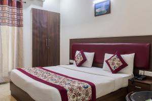 a bedroom with a large bed with a purple headboard at SKS Hospitality in Gurgaon +42 photos
