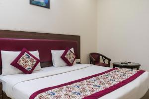 a bedroom with a large bed with red and white pillows at SKS Hospitality in Gurgaon