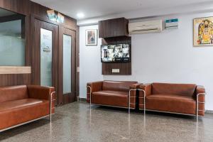 a waiting room with two leather chairs and a wall at SKS Hospitality in Gurgaon