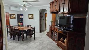 a living room with a dining table and a television at Casona El Rosedal in Bell Ville