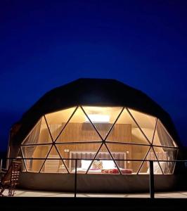 a round building with a black roof on a stage at Wadi rum trips in Wadi Rum
