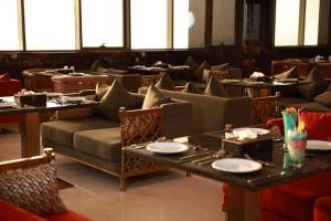 a restaurant with couches and tables with plates on them at Baghdad Do Hotel in Baghdād