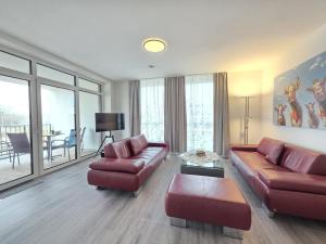 a living room with a couch and a chair at Ferienwohnung NorderHafen in Norden