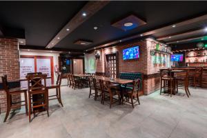 a restaurant with tables and chairs and a bar at Panacea Suites Hotel in Borg El Arab