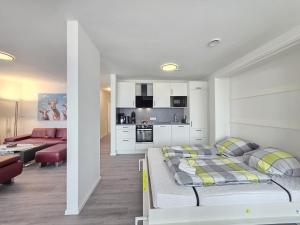 a bedroom with a bed and a living room at Ferienwohnung NorderHafen in Norden