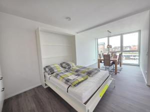 a bedroom with a bed and a dining room at Ferienwohnung NorderHafen in Norden