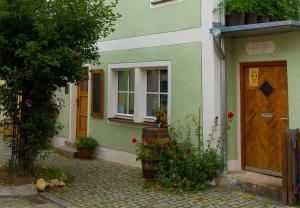 a green and white house with a door and flowers at An der KULTURSCHMIEDE in Kallmünz