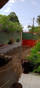 a yard with a red fence and some plants at Maison calme près de la mer in Mutsamudu