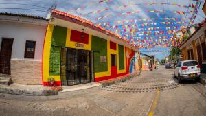 a street with a colorful building with a roof at Hostal Barrio Abajo in Barranquilla