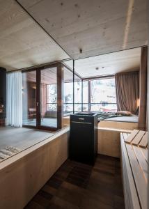 a room with a bed and a large window at Kersh Dolomites Lodge in San Candido