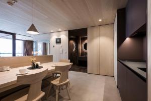 a kitchen and dining room with a table and chairs at Kersh Dolomites Lodge in San Candido
