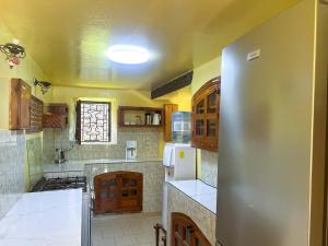 a large kitchen with wooden cabinets and white appliances at Résidence Soros - Île de Gorée in Dakar +58 photos