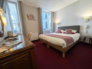 a hotel room with a large bed and a window at Hotel des Abers in Saint Malo