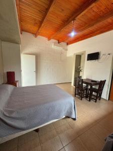 ein Schlafzimmer mit einem Bett und einem Tisch mit Stühlen in der Unterkunft El Teyu in Miramar