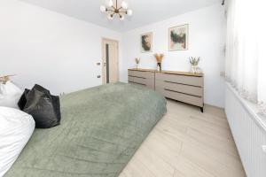ein weißes Schlafzimmer mit einem großen Bett und einer Kommode in der Unterkunft The performant in Satu Mare