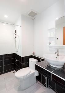 Łazienka z białą toaletą i umywalką w obiekcie Baan I Inspire w mieście Phrae
