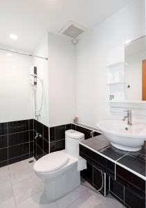 a bathroom with a white toilet and a sink at Baan I Inspire in Phrae