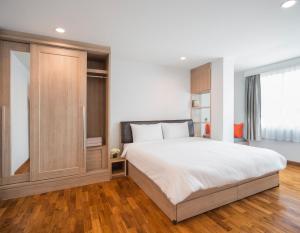 a bedroom with a large white bed and a window at Baan I Inspire in Phrae