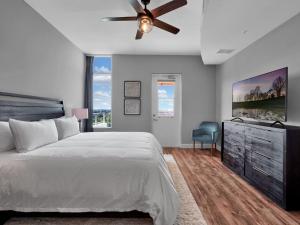 a bedroom with a bed and a ceiling fan at Luxurious Penthouse with large patio in Orlando