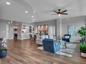a living room with blue chairs and a kitchen at Luxurious Penthouse with large patio in Orlando +41 photos