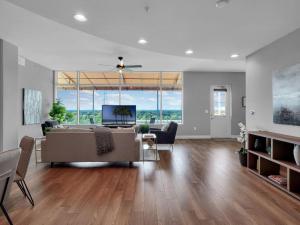 a living room with a couch and a tv at Luxurious Penthouse with large patio in Orlando