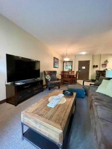 a living room with a large flat screen tv at 2 Bed 2 Bath with Fire Place in Fernie